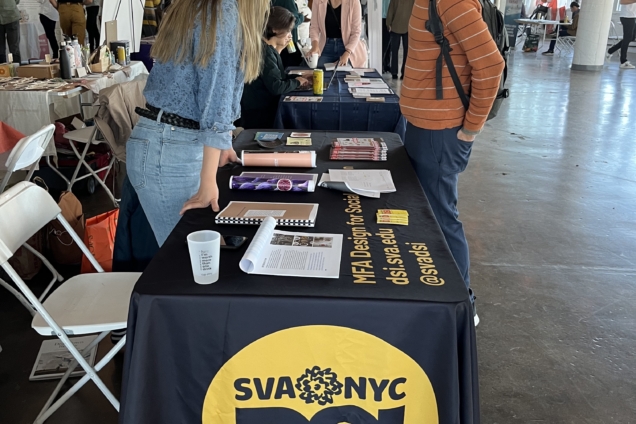 Alumna Kehan Zhang speaking with a visitor to the DSI table at the festival.