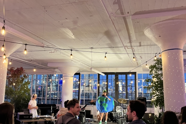 People watching a performance of a woman dressed as a globe.